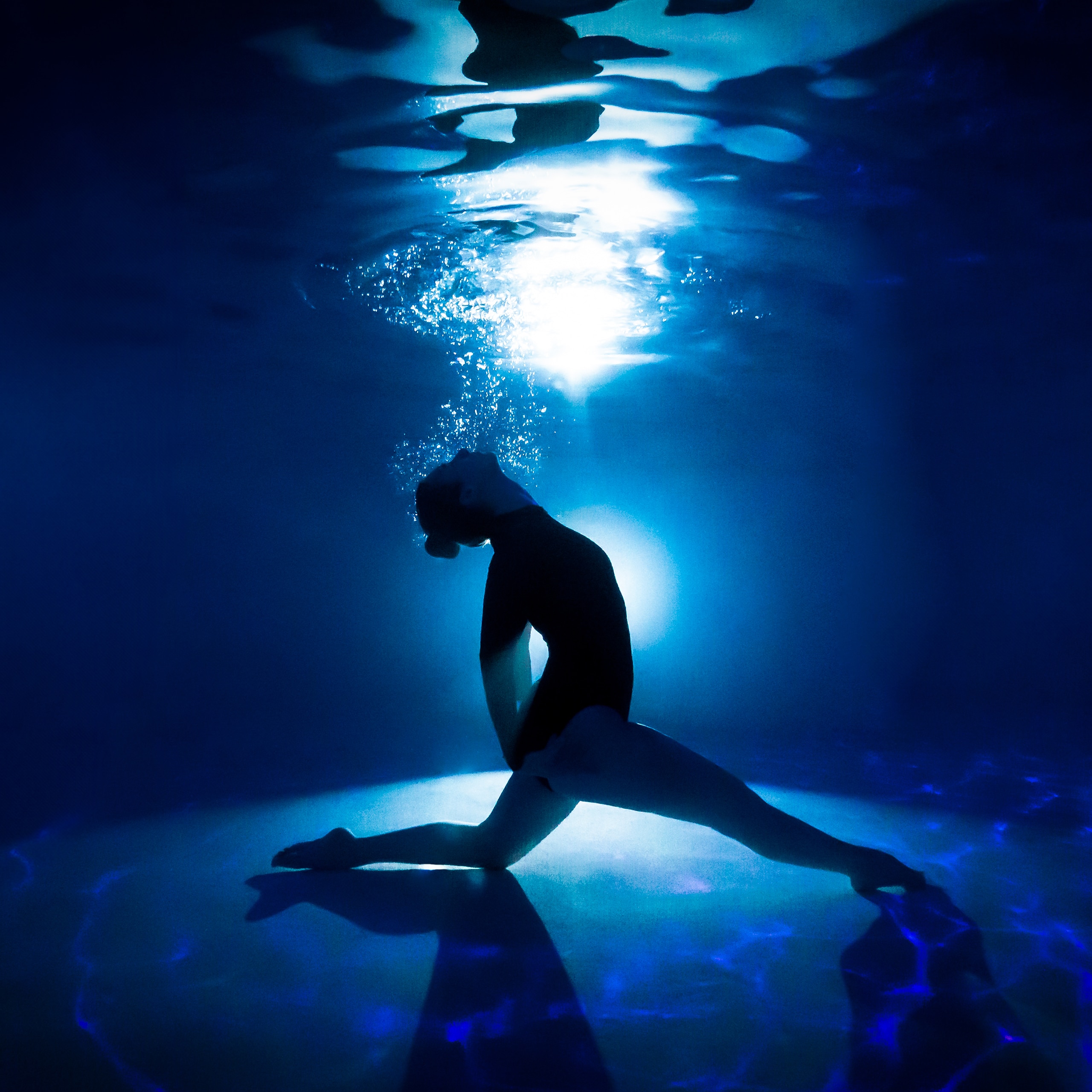 Portrait aquatique d'une danseuse de natation synchronisée durant une séance nocturne. ©Maxime Bonneau, Nautile Photographie, 2023.